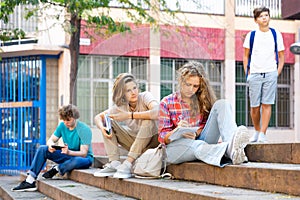 Teenagers on stairs beside of school