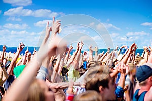 Teenagers at summer music festival clapping and singing