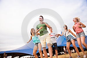 Teenagers at summer music festival dancing in front of tent