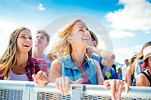 Teenagers at summer music festival dancing and singing