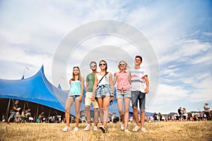 Teenagers at summer music festival in front of big blue tent