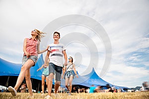 Teenagers at summer music festival in front of big blue tent