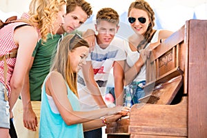 Teenagers at summer music festival, girl plays the piano