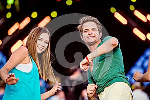 Teenagers at summer music festival having fun, dancing