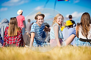 Teenagers at summer music festival, sitting on the grass