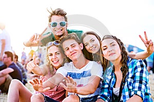 Teenagers at summer music festival, sitting on the ground