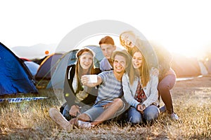 Teenagers at summer music festival, taking selfie with smartphon