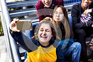 Teenagers taking selfie together with smartphone