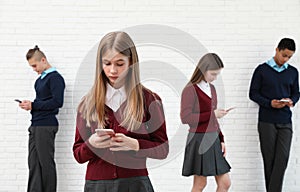 Teenagers using mobile phones at school. Concept of internet addiction