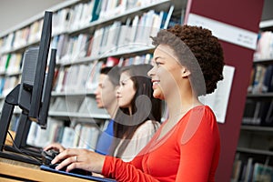 Teenagers working on computers in library