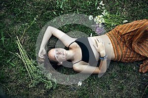 A teengirl is lying on the green grass, a picture from above.
