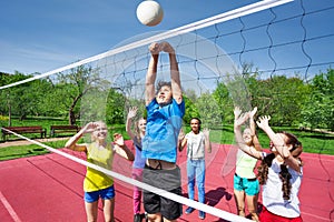 Teens all are with arms up play volleyball