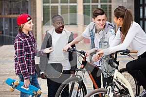 Teens chatting near bikes photo