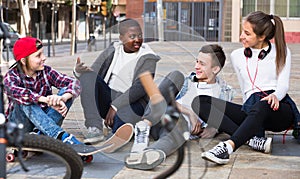 Teens chatting near bikes
