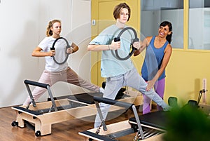 Teens doing pilates exercises with trainer