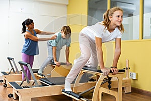 Teens doing pilates exercises with trainer