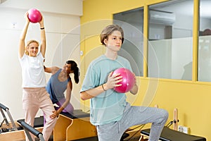 Teens doing pilates exercises with trainer