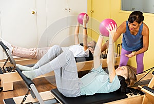 Teens doing pilates exercises with trainer