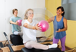 Teens doing pilates exercises with trainer