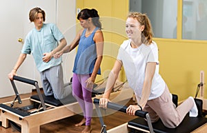 Teens doing pilates exercises with trainer