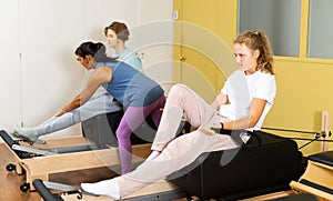 Teens doing pilates exercises with trainer