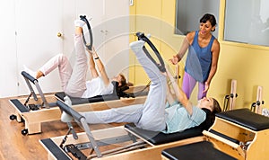Teens doing pilates exercises with trainer