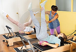 Teens doing pilates exercises with trainer