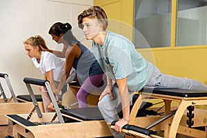 Teens doing pilates exercises with trainer