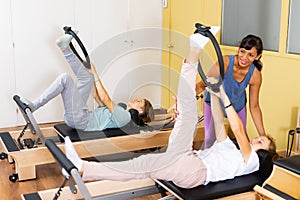 Teens doing pilates exercises with trainer