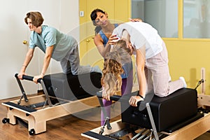 Teens doing pilates exercises with trainer