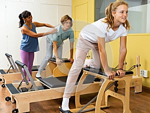 Teens doing pilates exercises with trainer