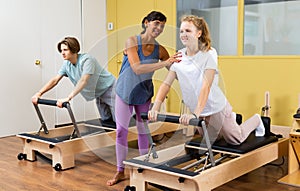 Teens doing pilates exercises with trainer