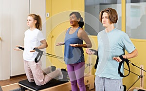 Teens doing pilates exercises with trainer