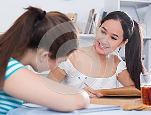 Teens girls doing homework and discussing