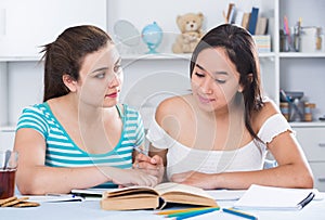 Teens girls doing homework and discussing