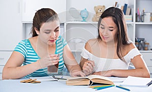 Teens girls doing homework and discussing