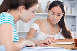 Teens girls doing homework and discussing