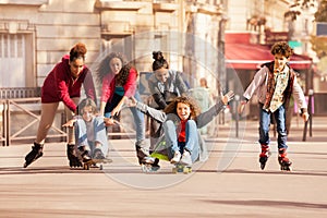 Teens having fun rollerblading and skateboarding