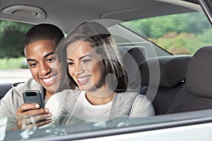 Teens looking at smartphone in car