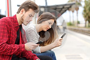 Teens obsessed with smart phones in a train station photo