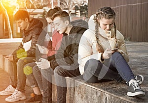 Teens with phones outdoors