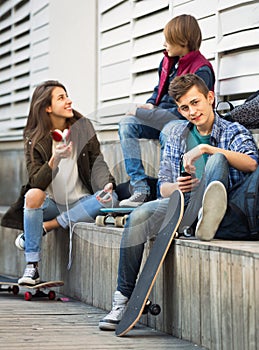 Teens playing on smarthphones and listening to music