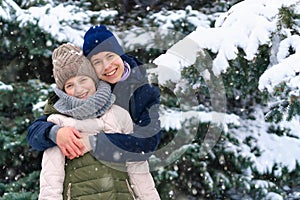 Teens portrait in a winter forest, boy and girl, beautiful nature with bright snowy fir trees