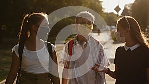 Teens with protective masks walk down the street