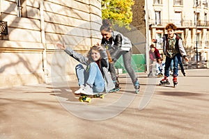 Teens riding fast on rollerblades and skateboard