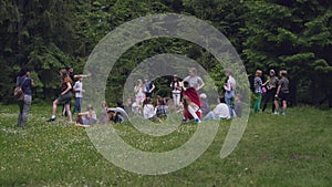 Teens sitting on mats in forest.