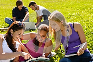 Teens studying in park reading book students