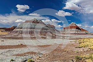 Teepee hill formations, Petrified Forest National Park. Colored layers of sediment blue sky and clouds.