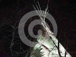 Teepee With White Light Against A Dark Sky