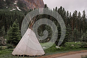 A teepee wigwam tent is standing alone in the forest. Active recreation in the mountains